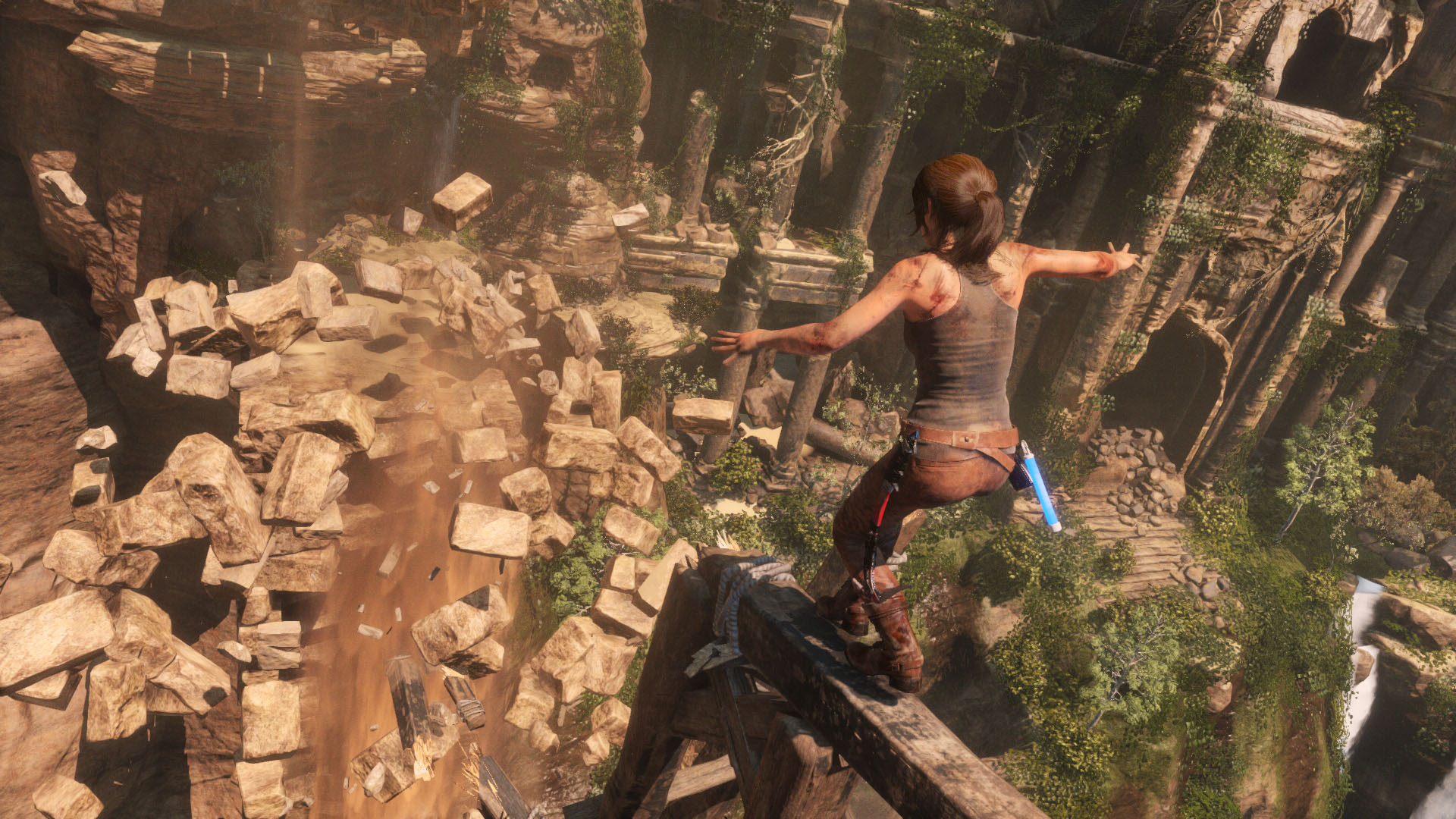 Lara balances herself on a broken beam as the rock platform ahead of her crumbles.